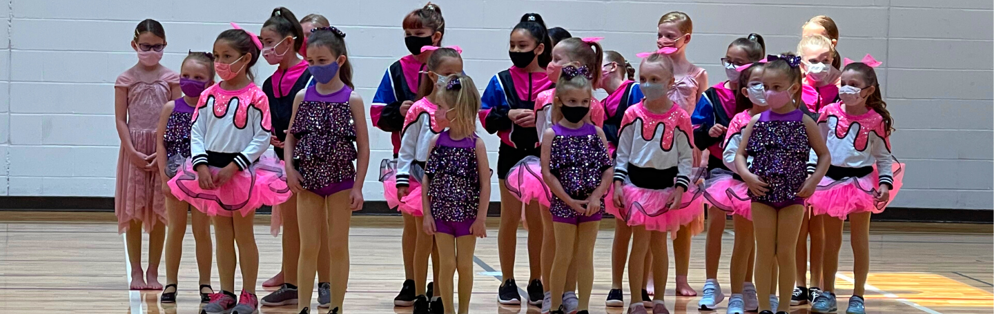 A group of youth dancers posing for a picture after the end of a performance